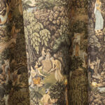 Tessuto decorativo ispirato a scene esotiche, raffigurante donne in abiti tradizionali immerse in una lussureggiante foresta tropicale con cascate, alberi imponenti e vegetazione rigogliosa. I toni caldi del verde, marrone e ocra creano un design ricco e suggestivo, ideale per arredamenti etnici, tende, cuscini e decorazioni d'interni in stile tropicale.