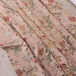 Tessuto lampasso in stile veneziano con fondo rosa antico e motivo floreale barocco ricamato in tonalità oro, rosso, verde oliva e azzurro. Elegante e raffinato, ideale per tendaggi, cuscini, tappezzerie e complementi d’arredo classici. Pregiata manifattura italiana.