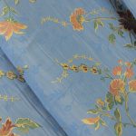 Lampasso fabric with light blue background and woven floral pattern in classic style. Flowers in shades of red, orange and yellow with green leaves, perfect for curtains, pillows, upholstery and shabby chic decorations. Elegant and vibrant print for decorating with personality. Made in Italy.