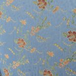 Lampasso fabric with light blue background and woven floral pattern in classic style. Flowers in shades of red, orange and yellow with green leaves, perfect for curtains, pillows, upholstery and shabby chic decorations. Elegant and vibrant print for decorating with personality. Made in Italy.