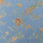 Lampasso fabric with light blue background and woven floral pattern in classic style. Flowers in shades of red, orange and yellow with green leaves, perfect for curtains, pillows, upholstery and shabby chic decorations. Elegant and vibrant print for decorating with personality. Made in Italy.