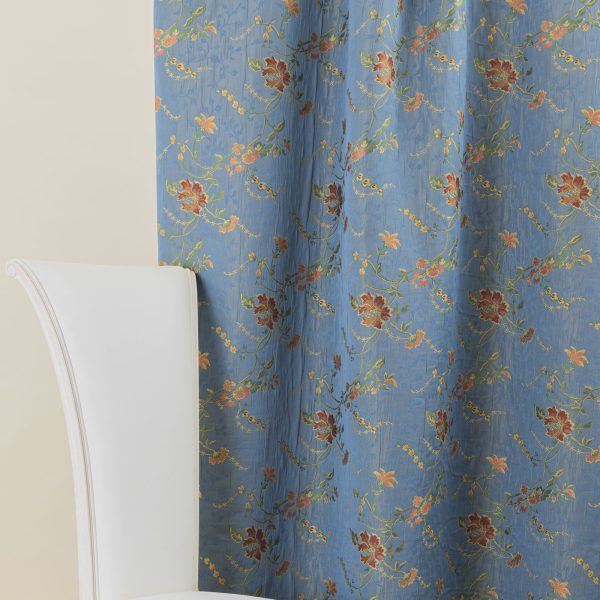 Lampasso fabric with light blue background and woven floral pattern in classic style. Flowers in shades of red, orange and yellow with green leaves, perfect for curtains, pillows, upholstery and shabby chic decorations. Elegant and vibrant print for decorating with personality. Made in Italy.