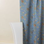 Lampasso fabric with light blue background and woven floral pattern in classic style. Flowers in shades of red, orange and yellow with green leaves, perfect for curtains, pillows, upholstery and shabby chic decorations. Elegant and vibrant print for decorating with personality. Made in Italy.