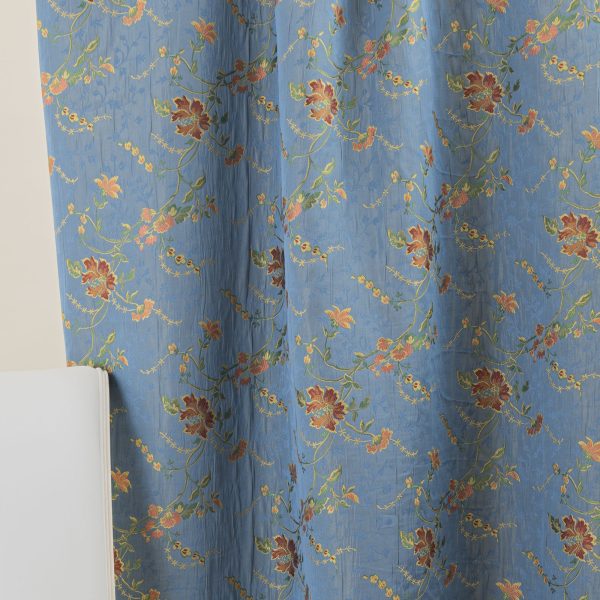 Lampasso fabric with light blue background and woven floral pattern in classic style. Flowers in shades of red, orange and yellow with green leaves, perfect for curtains, pillows, upholstery and shabby chic decorations. Elegant and vibrant print for decorating with personality. Made in Italy.