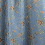 Lampasso fabric with light blue background and woven floral pattern in classic style. Flowers in shades of red, orange and yellow with green leaves, perfect for curtains, pillows, upholstery and shabby chic decorations. Elegant and vibrant print for decorating with personality. Made in Italy.